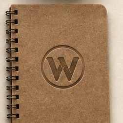 Kraft spiral notebook with the W mark pressed into the cover